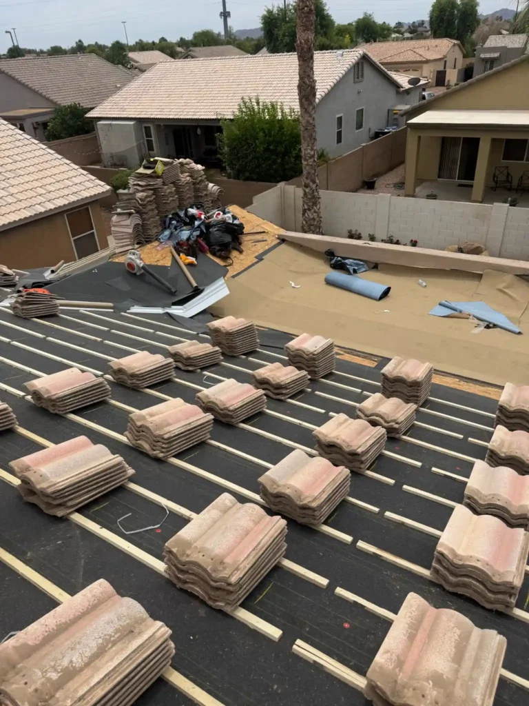 Concrete tile stacked on battens with roof deck exposed during underlayment replacement
